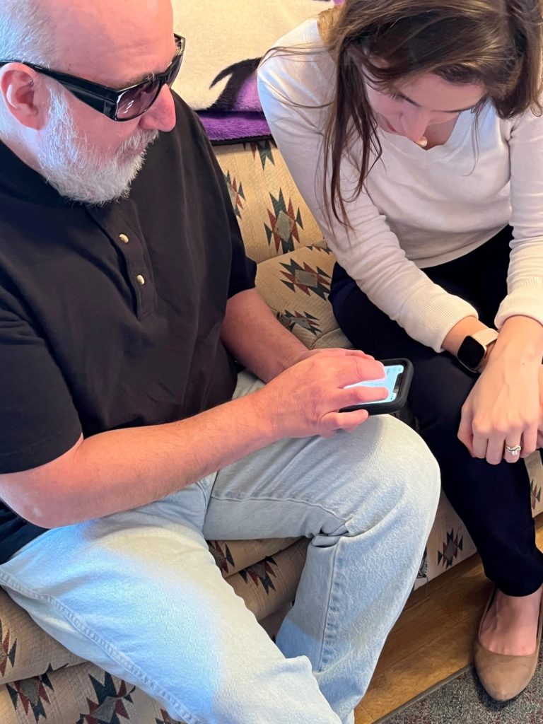 Client Carl using iPhone with the of Vision Rehab Therapist Kristen
